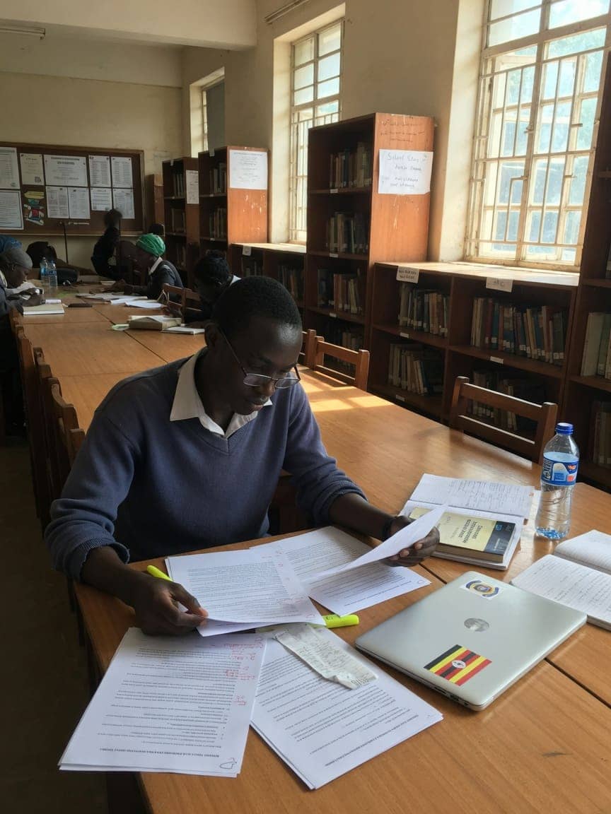 University-entry candidate reading papers at a library table